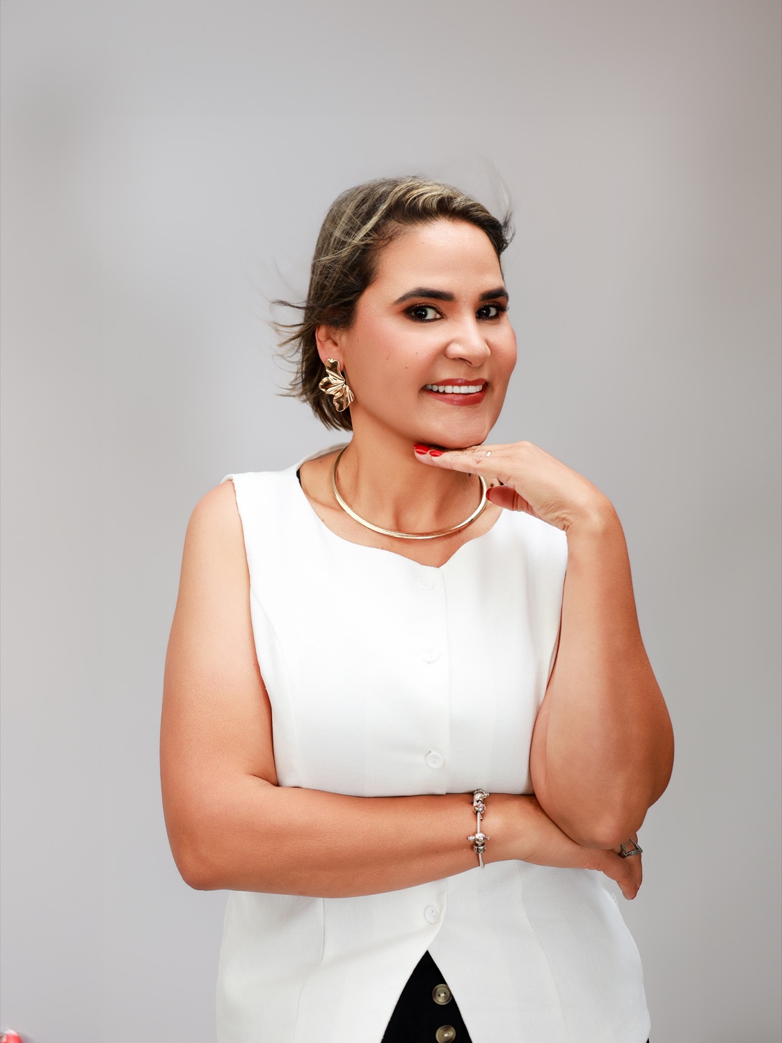 Warm portrait of Marlene Eggea smiling, hand resting on her chin.
